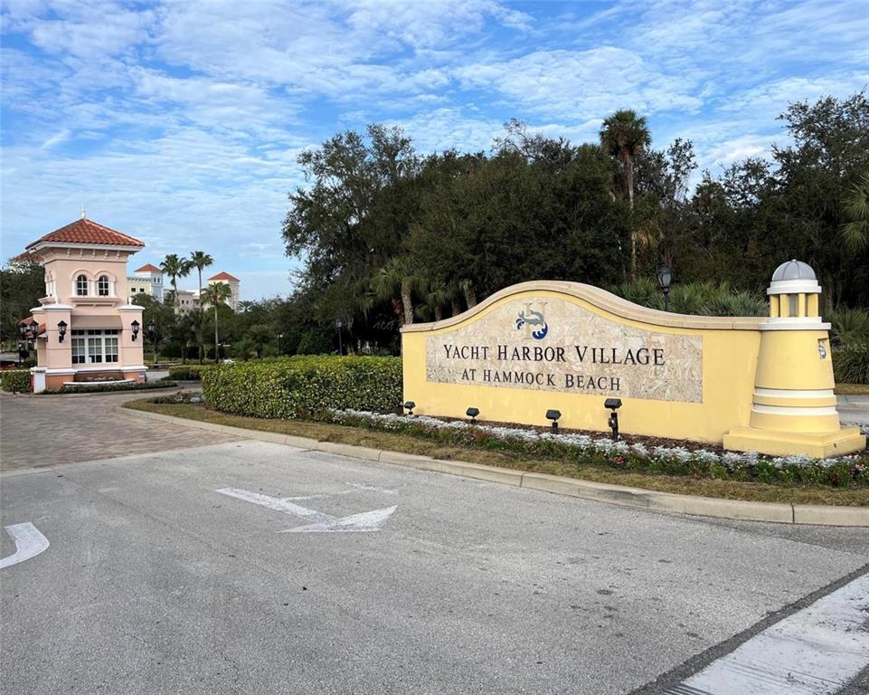 A yellow monument sign marks the entrance to Yacht Harbor Village at Hammock Beach — 234 HARBOR VILLAGE POINT N, PALM COAST, FL