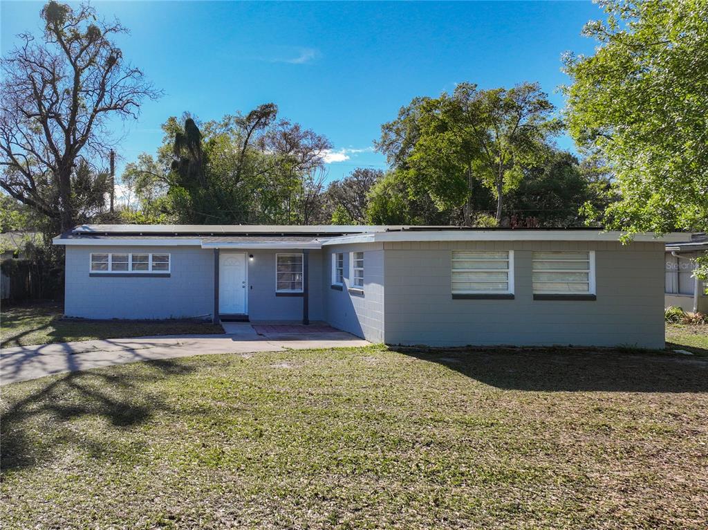 A single-story gray concrete block house with a flat roof and a front driveway — 3802 WESTGATE ROAD, ORLANDO, FL