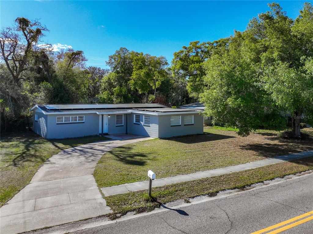 A single-story gray house with a flat roof and a concrete driveway sits on a lawn — 3802 WESTGATE ROAD, ORLANDO, FL