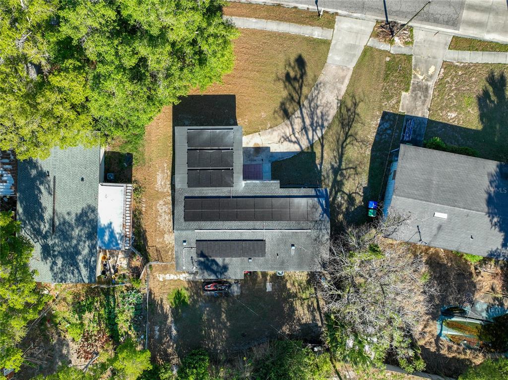 An aerial view shows a house with solar panels on the roof and a driveway — 3802 WESTGATE ROAD, ORLANDO, FL