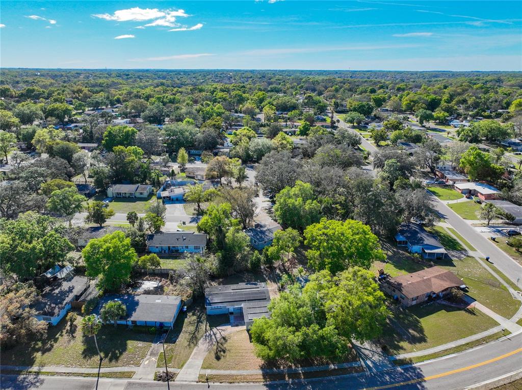 An aerial view shows a suburban neighborhood with single-story houses, mature trees, and paved streets — 3802 WESTGATE ROAD, ORLANDO, FL