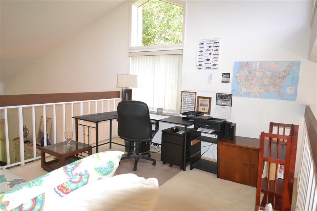 A loft office space features a desk, chair, printer, wall map, and a vaulted ceiling — 112 LINDSAY LANE, OLDSMAR, FL