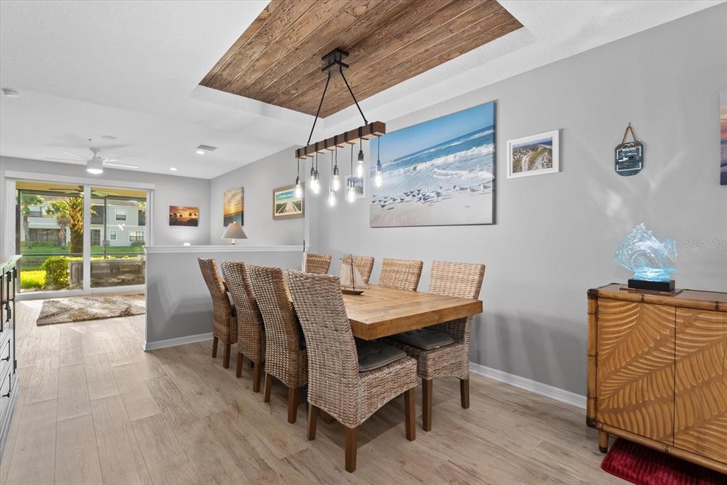 A dining room features a wooden table, wicker chairs, and a wood-paneled tray ceiling — 4190 OVERTURE CIRCLE UNIT 511, BRADENTON, FL