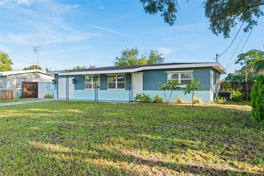 A single-story house with a blue exterior, light blue base, and a front-facing garage — 10811 VALENCIA TERRACE, SEMINOLE, FL