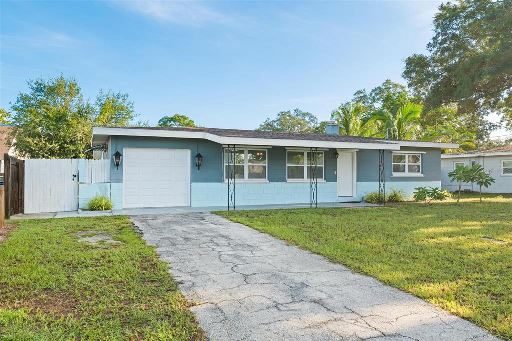 A single-story house with a blue and light blue exterior, a garage, and a driveway — 10811 VALENCIA TERRACE, SEMINOLE, FL