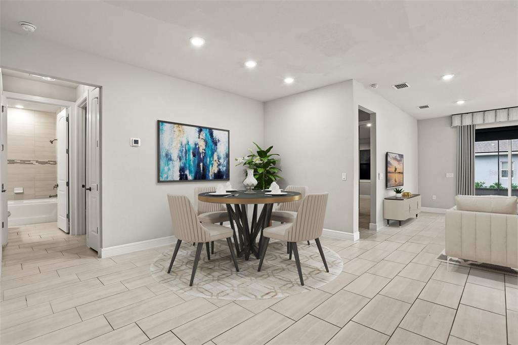 A dining area with a round table and chairs sits on a light-colored tiled floor — 13355 SUNNY RETREAT LANE, WINTER GARDEN, FL