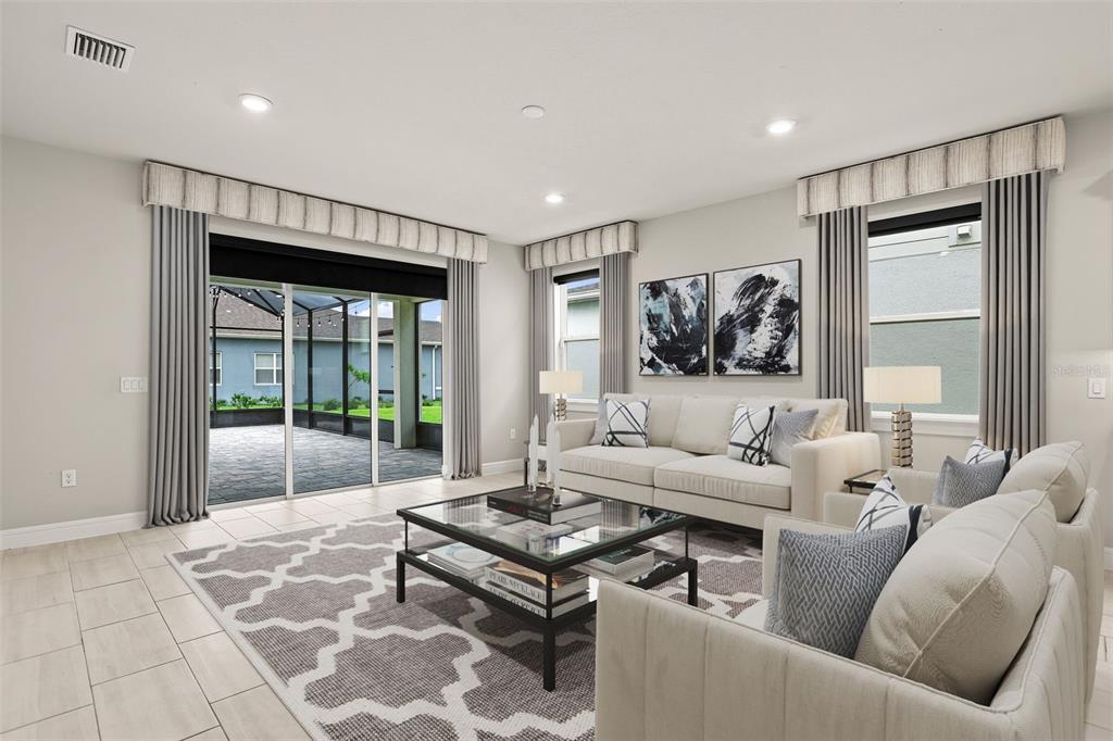 A living room features a glass sliding door, a patterned area rug, and neutral-toned furniture — 13355 SUNNY RETREAT LANE, WINTER GARDEN, FL