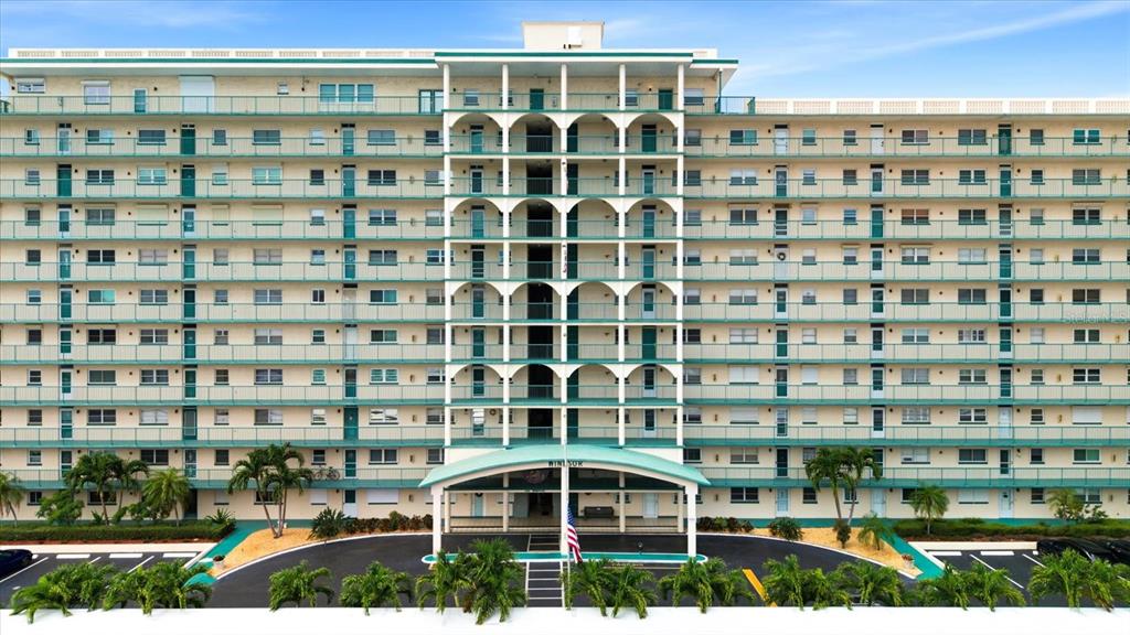 An aerial view shows three large apartment buildings with covered parking lots along a bay — 6020 SHORE BOULEVARD S UNIT 1002, GULFPORT, FL