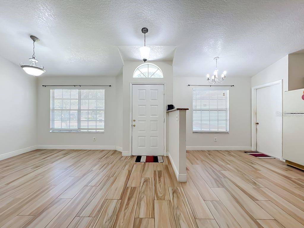 An empty room with light-colored walls, wood-look tile flooring, and a window with white blinds — 8818 RESERVATION DRIVE, ORLANDO, FL