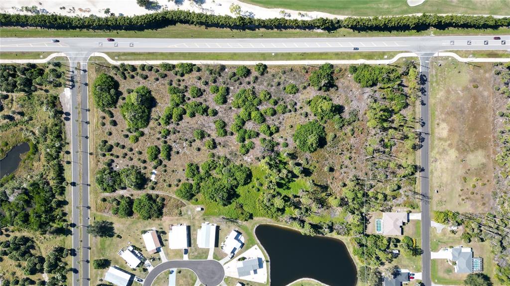 An aerial view shows a vacant, wooded lot bordered by roads and residential houses — 6631 PLACIDA ROAD, ENGLEWOOD, FL