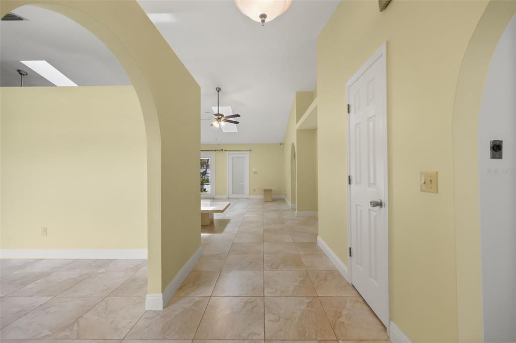 An open-concept living and dining area features tile flooring, vaulted ceilings with skylights, and lighting — 2243 BANCROFT BOULEVARD, ORLANDO, FL