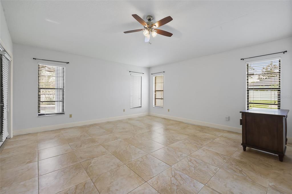 A room with beige walls, tile flooring, and an arched entryway leading to a kitchen — 2243 BANCROFT BOULEVARD, ORLANDO, FL