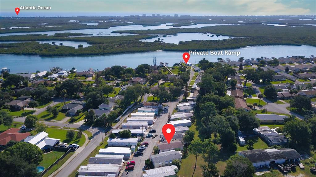 An aerial view shows a residential neighborhood near a waterway with a private boat ramp — 2201 S RIDGEWOOD AVENUE UNIT 28, EDGEWATER, FL