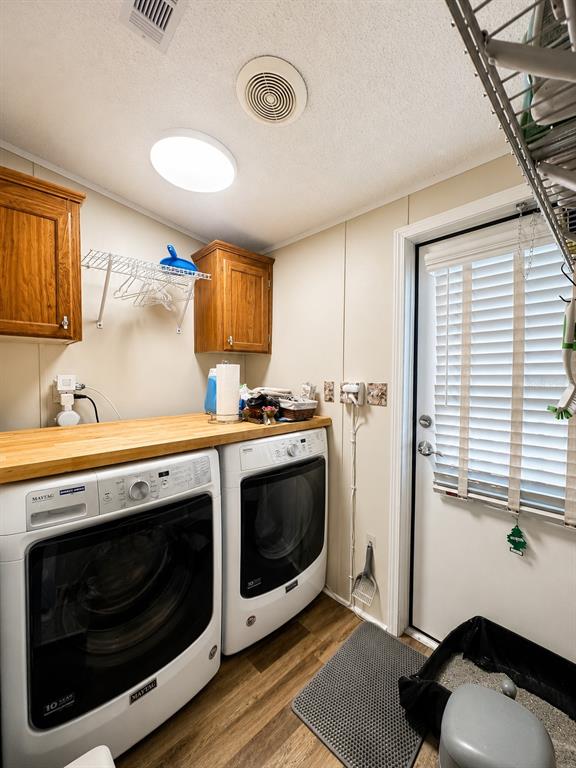 A laundry room features a wooden countertop over two white Maytag appliances and a door — 2201 S RIDGEWOOD AVENUE UNIT 28, EDGEWATER, FL