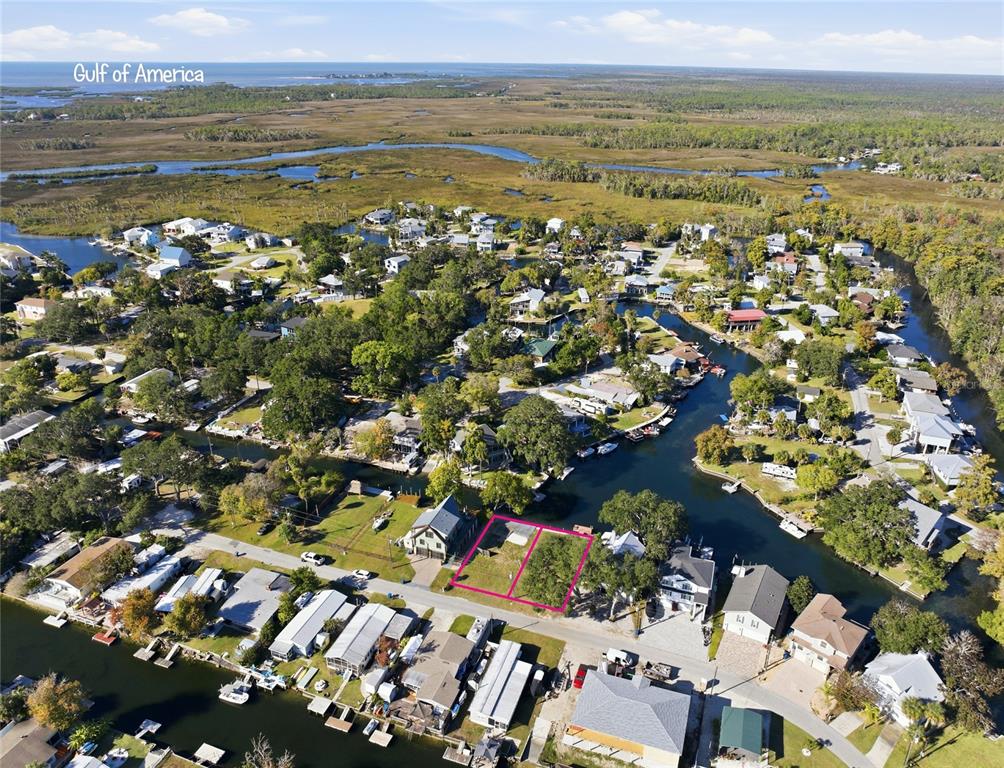 An aerial view shows two adjacent vacant waterfront lots highlighted in pink within a residential neighborhood — 00 CIRCLE DRIVE, WEEKI WACHEE, FL