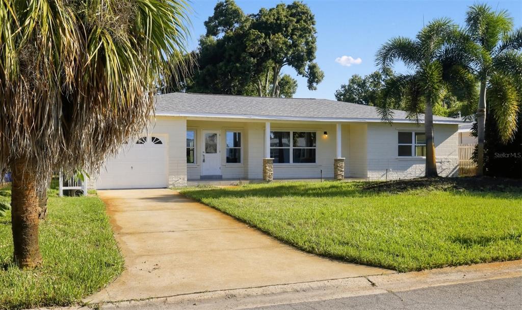 A single-story house with a white brick exterior, a covered front porch, and a concrete driveway — 5825 21ST AVENUE S, GULFPORT, FL