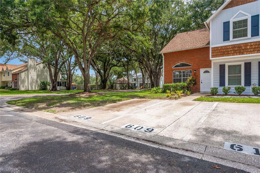 A two-story brick and siding townhouse features two designated parking spaces in front — 609 SAINT HENRY DRIVE, BRANDON, FL