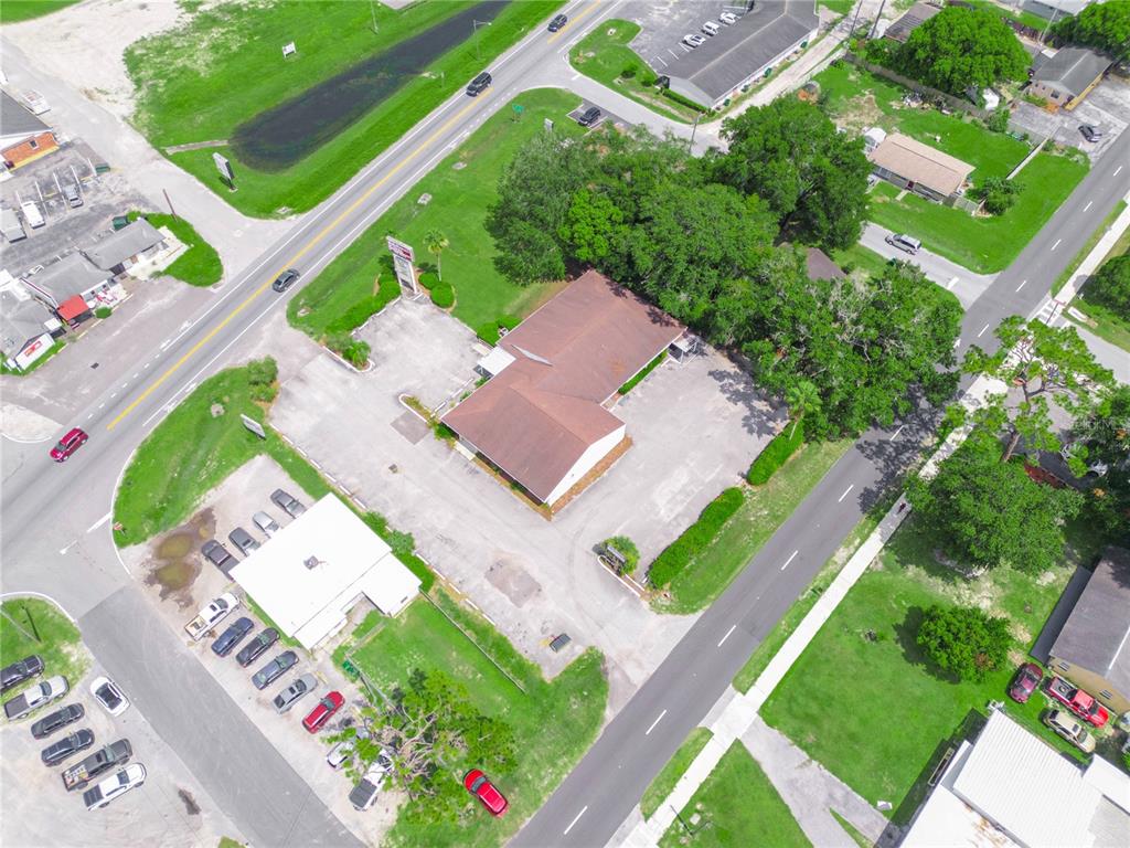 An aerial view shows a commercial building with a brown roof surrounded by parking lots — 5821 GALL BOULEVARD, ZEPHYRHILLS, FL
