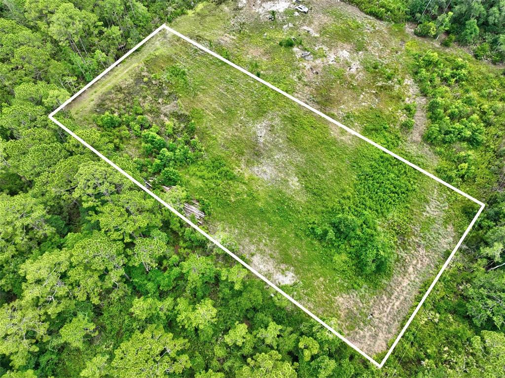 An aerial view shows a rectangular, cleared plot of land surrounded by dense forest — KINGS ESTATE RD, ST AUGUSTINE, FL