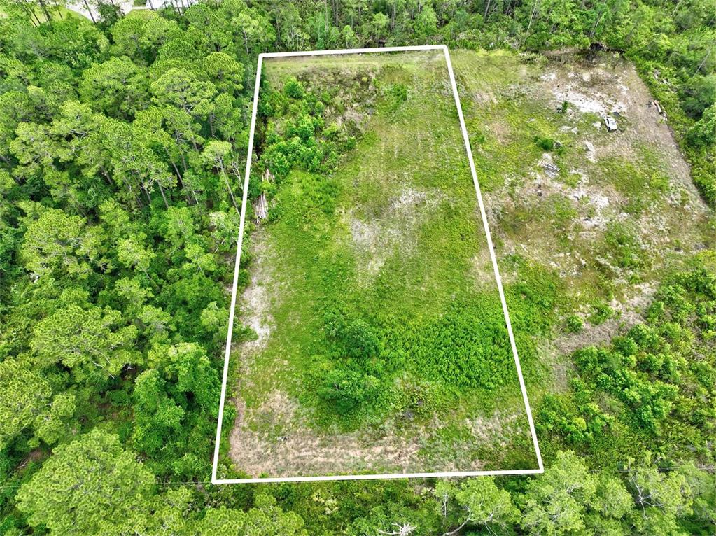 An aerial view shows a rectangular plot of cleared land surrounded by dense forest — KINGS ESTATE RD, ST AUGUSTINE, FL