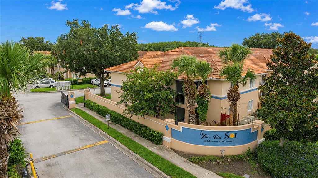 A two-story apartment building with tan stucco walls, a tiled roof, and palm trees — 508 VILLA DEL SOL CIRCLE UNIT 204, ORLANDO, FL