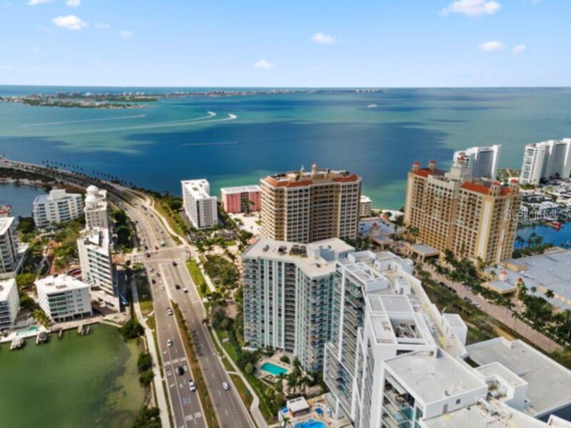 An aerial view of high-rise apartment buildings located along a coastal highway and bay — 1111 N GULFSTREAM AVENUE UNIT 6B, SARASOTA, FL