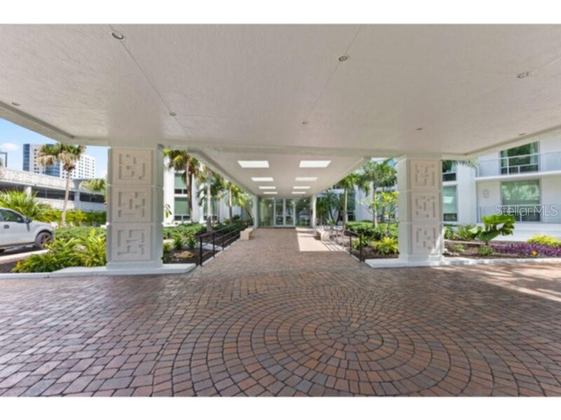 A paved circular driveway leads to a covered entrance with decorative pillars at a building — 1111 N GULFSTREAM AVENUE UNIT 6B, SARASOTA, FL