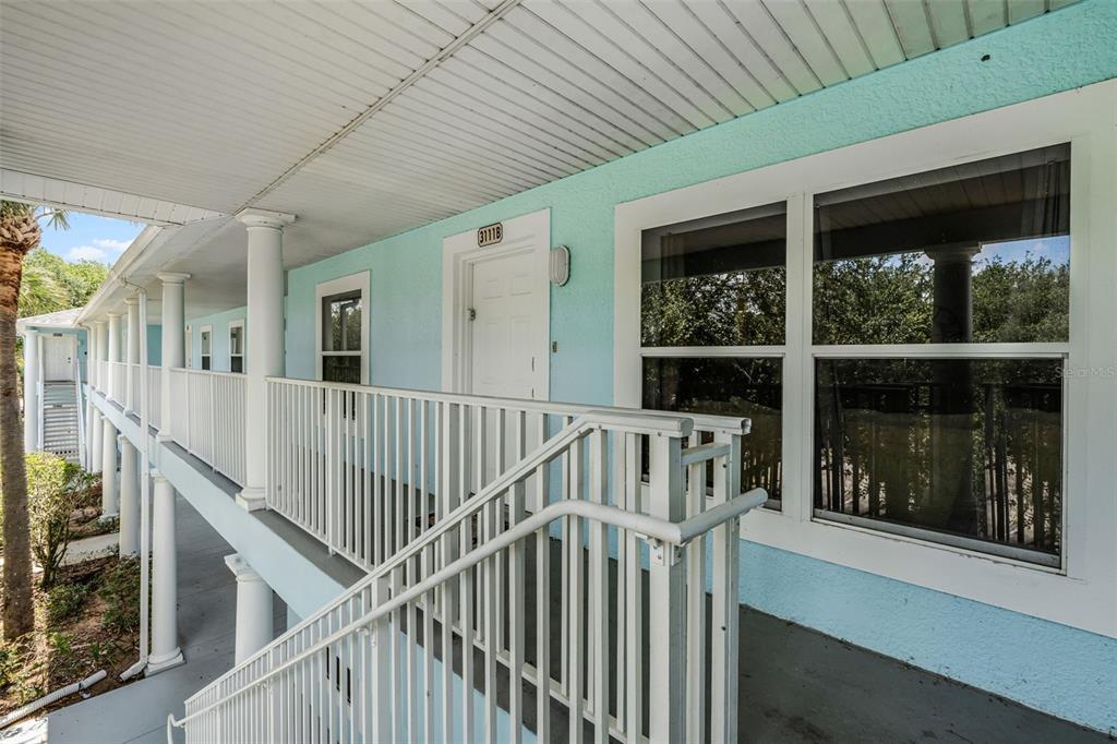 A living room with tile flooring, a large area rug, and a dining area beyond — 3111 SUN LAKE COURT UNIT B, KISSIMMEE, FL