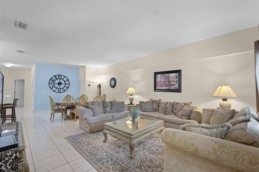 A living room features beige tile floors, two tan sofas, a coffee table, and a television — 3111 SUN LAKE COURT UNIT B, KISSIMMEE, FL