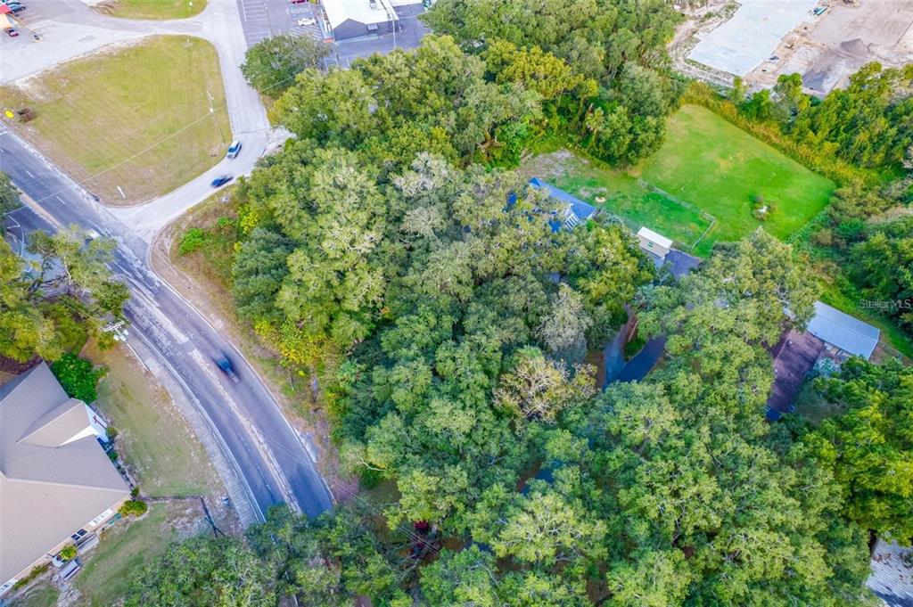 An aerial view shows a wooded residential property with a house surrounded by dense trees — 11433 WELDON STREET, SEFFNER, FL