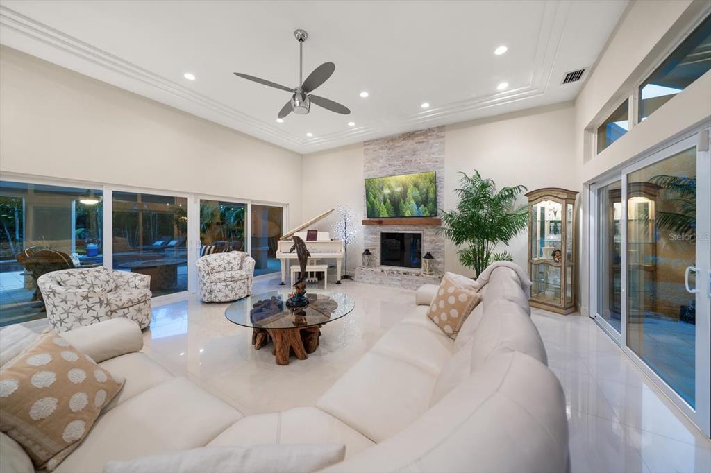A bright entryway features a double glass door, a large oval mirror, and a console table — 485 PARK AVENUE, BELLEAIR, FL