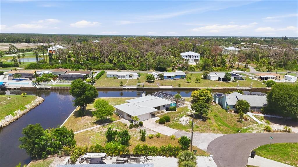 An aerial view shows a waterfront house with a pool and dock along a canal — 898 E 6TH STREET, ENGLEWOOD, FL