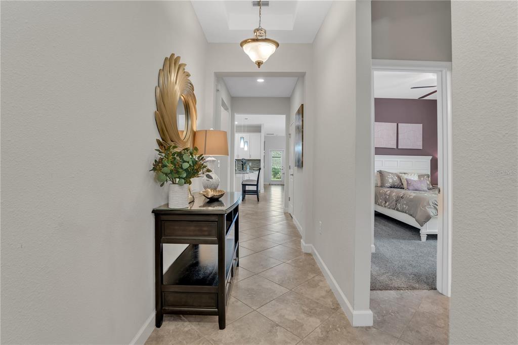 A tiled hallway leads past a console table to a kitchen and a bedroom doorway — 1419 PRO SHOP CT, DAVENPORT, FL