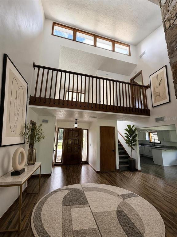 A kitchen features white cabinets, granite countertops, and wood-look flooring — 2598 ENTERPRISE OSTEEN ROAD, OSTEEN, FL