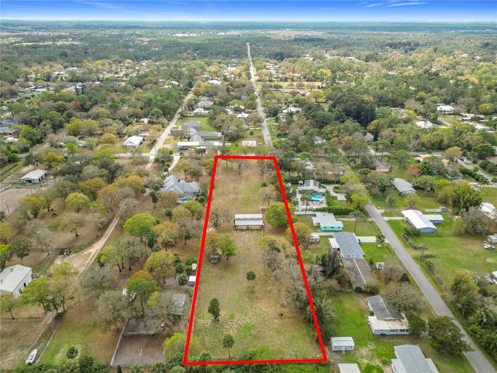 An aerial view shows a long, rectangular vacant lot outlined in red within a residential neighborhood — 3900 MIAMI AVENUE, MELBOURNE, FL