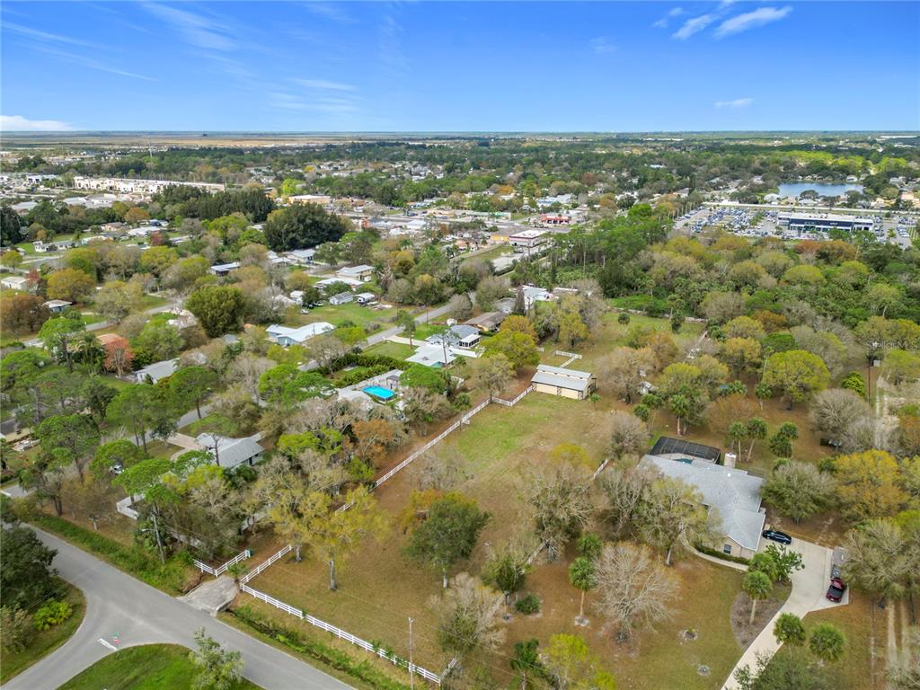 An aerial view shows a large residential lot with a house, barn, and fenced yard — 3900 MIAMI AVENUE, MELBOURNE, FL