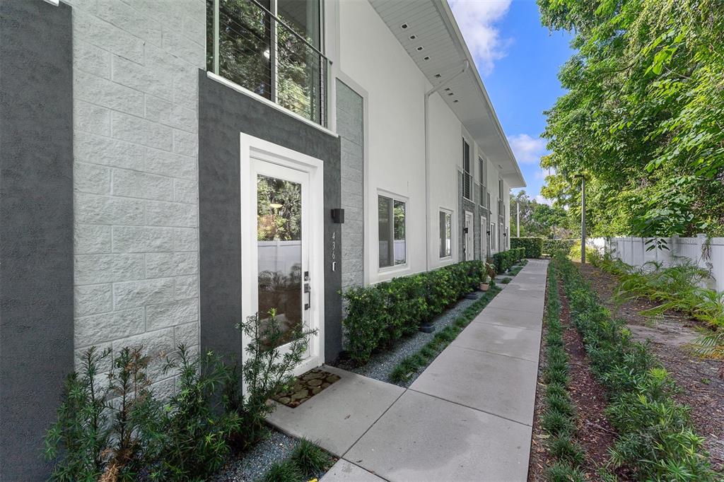 A modern two-story townhouse exterior features a white facade, dark gray accents, and a concrete walkway — 436 W SWOOPE AVENUE, WINTER PARK, FL