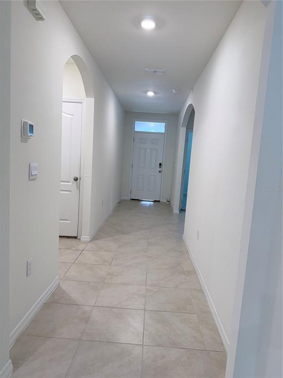 A single-story house with a beige exterior, a two-car garage, and a front lawn — 1344 SUGARWOOD STREET, DAVENPORT, FL