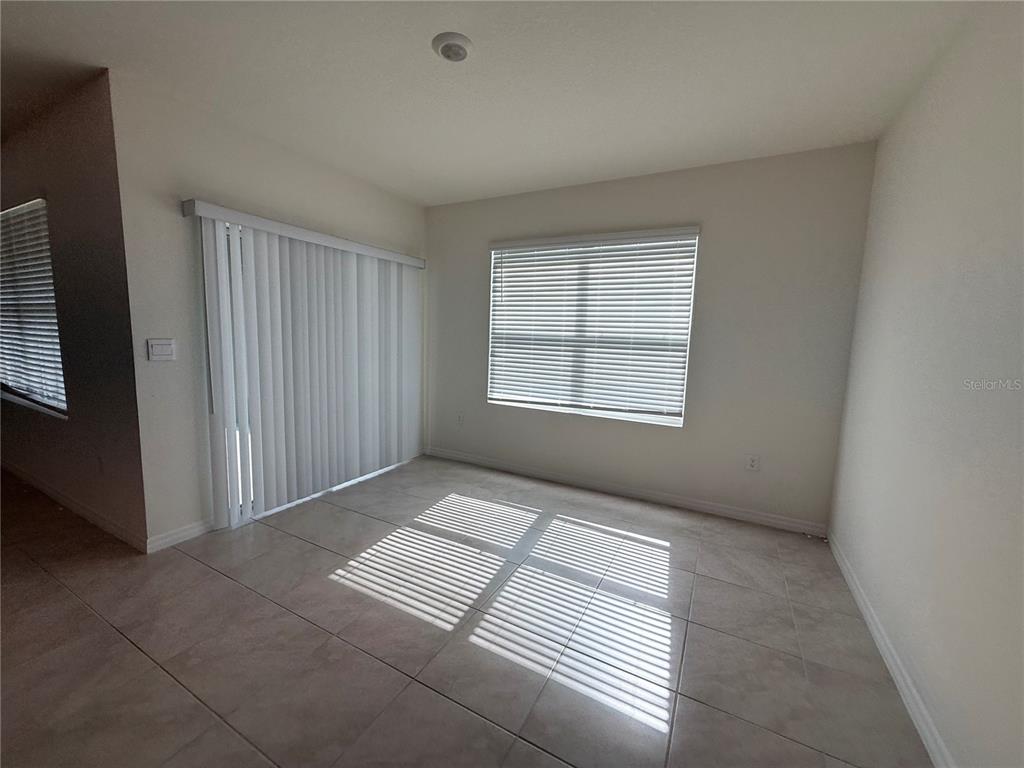A kitchen with white cabinets, granite countertops, a center island, and stainless steel appliances — 1344 SUGARWOOD STREET, DAVENPORT, FL