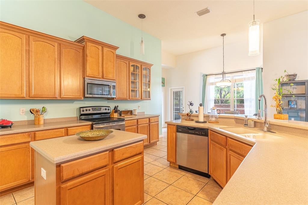 A kitchen with light wood cabinets, a central island, and light blue walls — 2539 CENTENNIAL FALCON DRIVE, VALRICO, FL