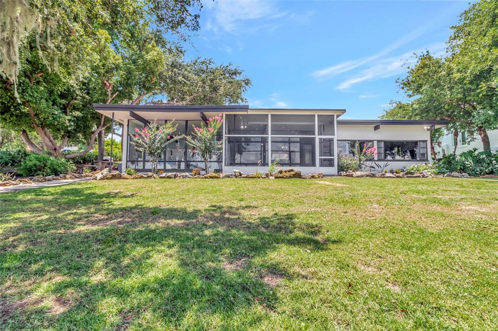 A mid-century modern house with a flat roof and a large screened-in porch — 11900 ELBERT STREET, CLERMONT, FL