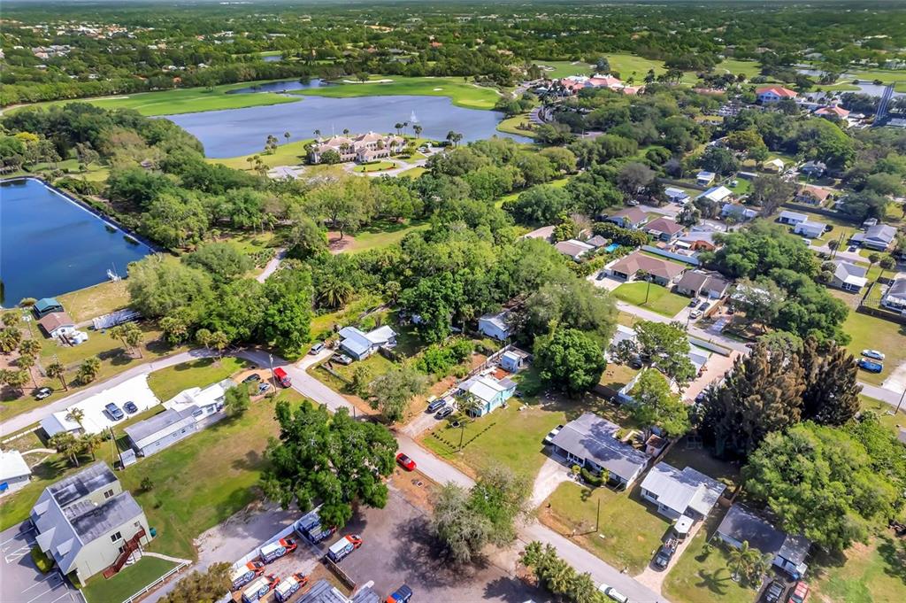 An aerial view shows a residential neighborhood with houses, trees, and a large lake — 456 WASHINGTON AVENUE, OSPREY, FL