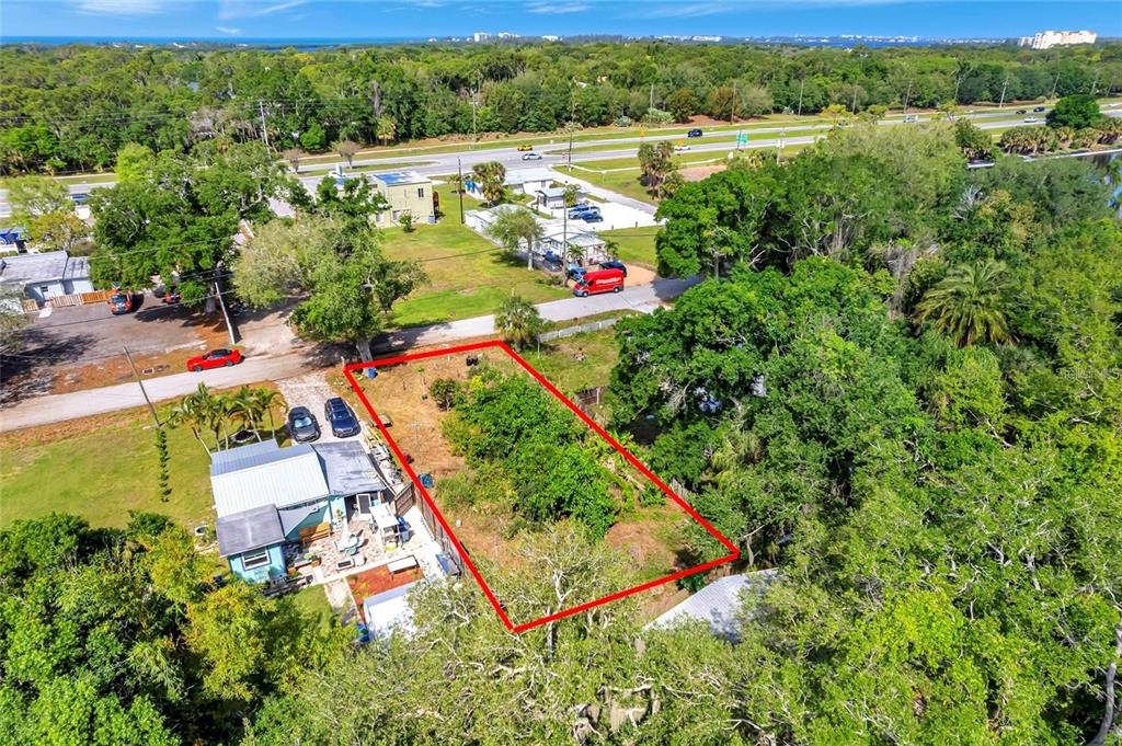 An aerial view shows a rectangular vacant lot outlined in red next to a house — 456 WASHINGTON AVENUE, OSPREY, FL