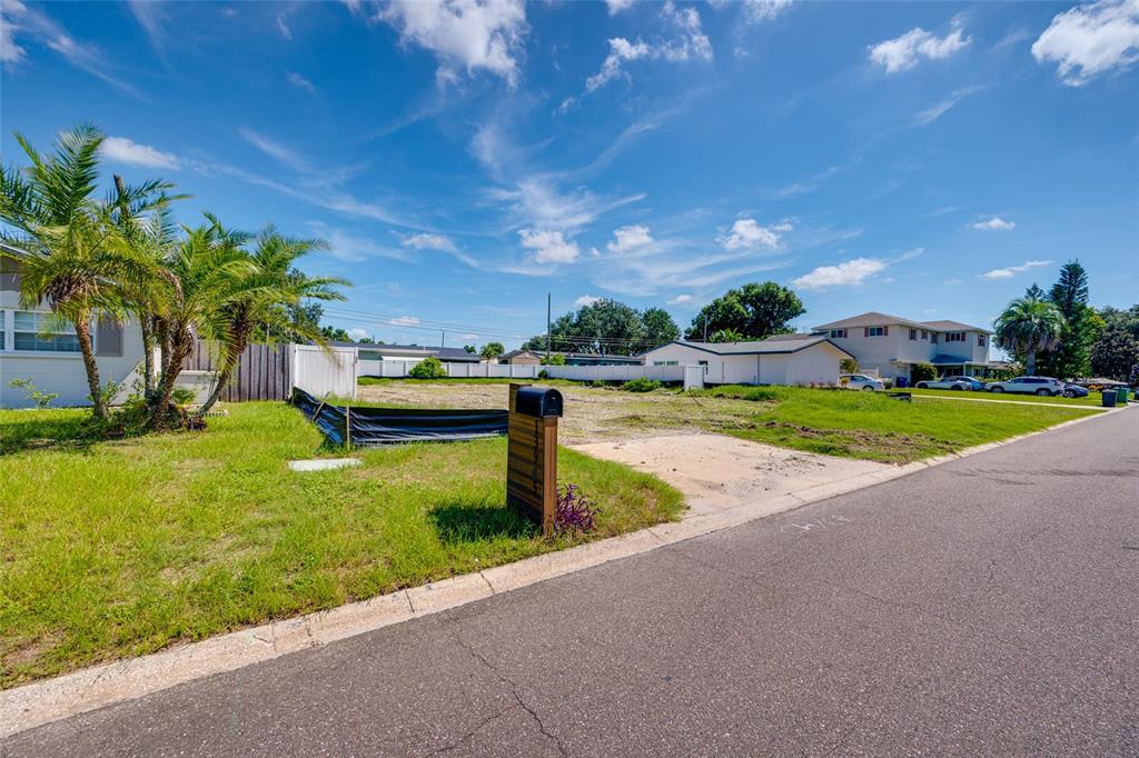 A vacant residential lot with a mailbox and palm trees under a blue sky — 13945 TRINIDAD DRIVE, SEMINOLE, FL