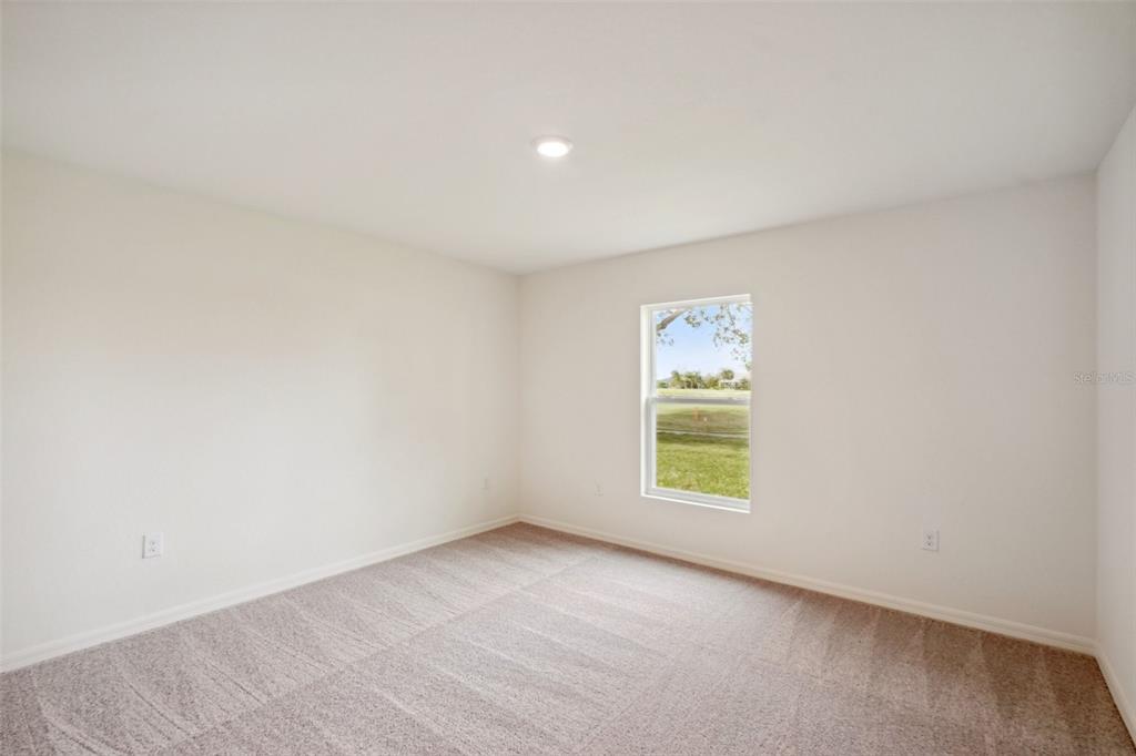 A single-story white house with a two-car garage and a concrete driveway — 15477 DUSKY SPARROW ROAD, WEEKI WACHEE, FL