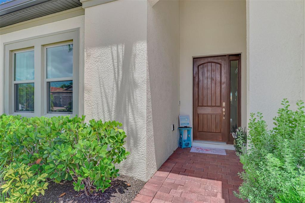 A single-story house with a brick paver driveway, a three-car garage, and a palm tree — 292 VILLORESI BOULEVARD, NORTH VENICE, FL