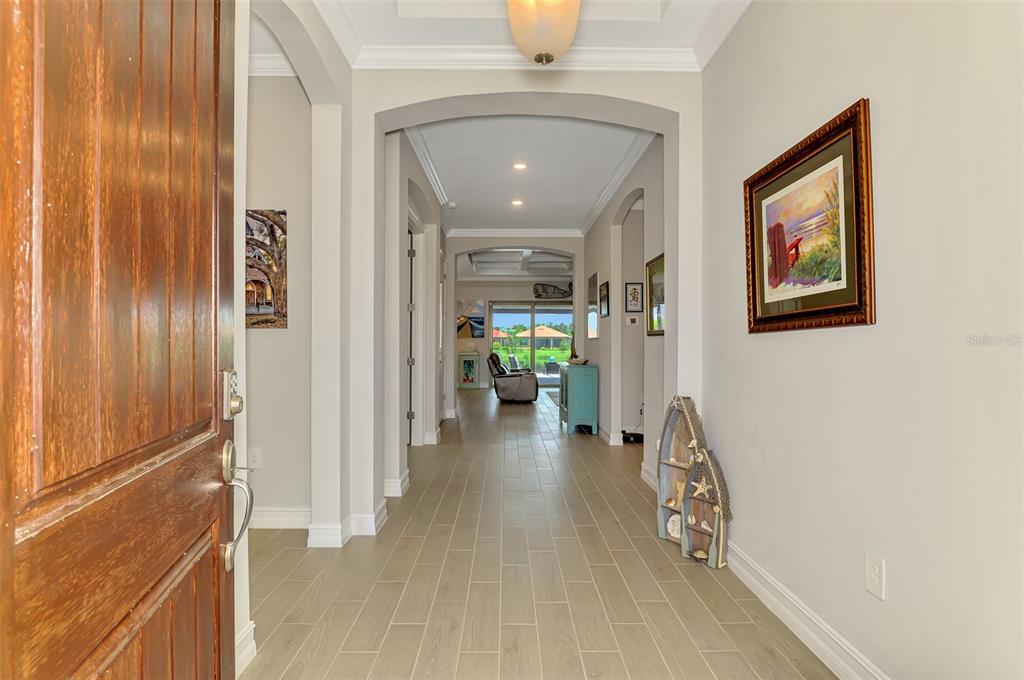 A front entryway features a wooden door, a brick walkway, and surrounding landscaping — 292 VILLORESI BOULEVARD, NORTH VENICE, FL