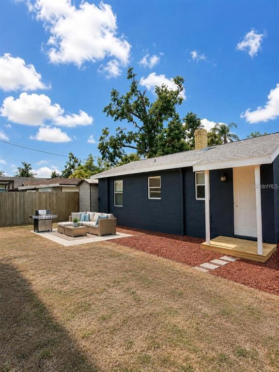 A dark-painted house exterior features a palm tree, a concrete walkway, and a small porch — 6712 S GABRIELLE STREET, TAMPA, FL