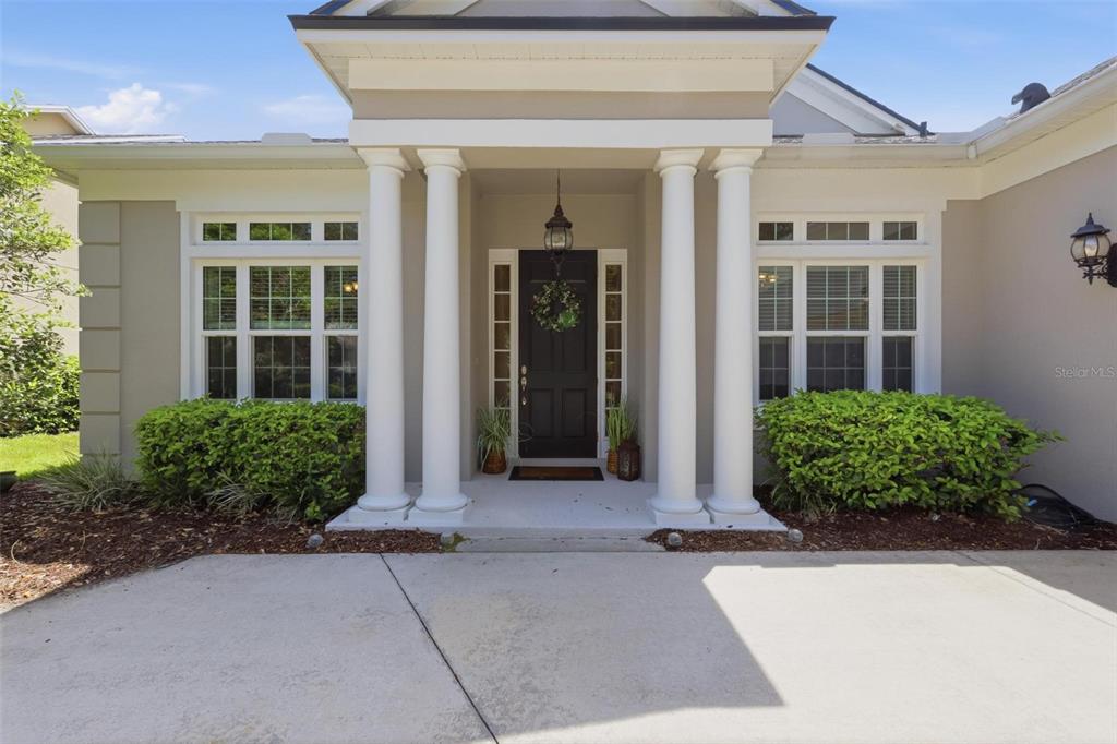 The exterior of a house features a covered entryway with four white columns and a door — 300 BELLINGRATH TERRACE, DELAND, FL