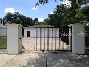 A detached garage sits behind a gated driveway entrance with two white concrete pillars — 1003 W SUMNER STREET, KISSIMMEE, FL